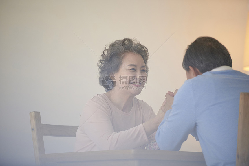 餐桌上面对面坐着的夫妇图片