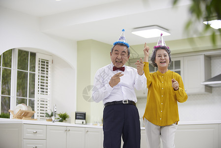 戴着帽子庆祝开心的老年夫妇图片