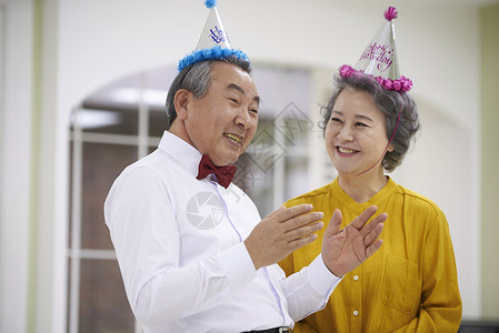 戴着帽子庆祝节日开心的老年夫妇图片