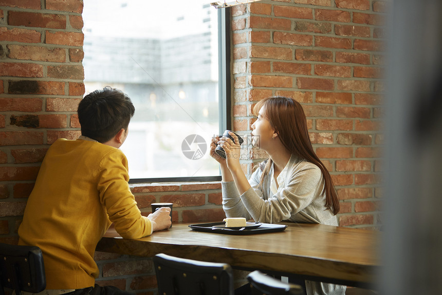 喝咖啡看向窗外的年轻情侣图片