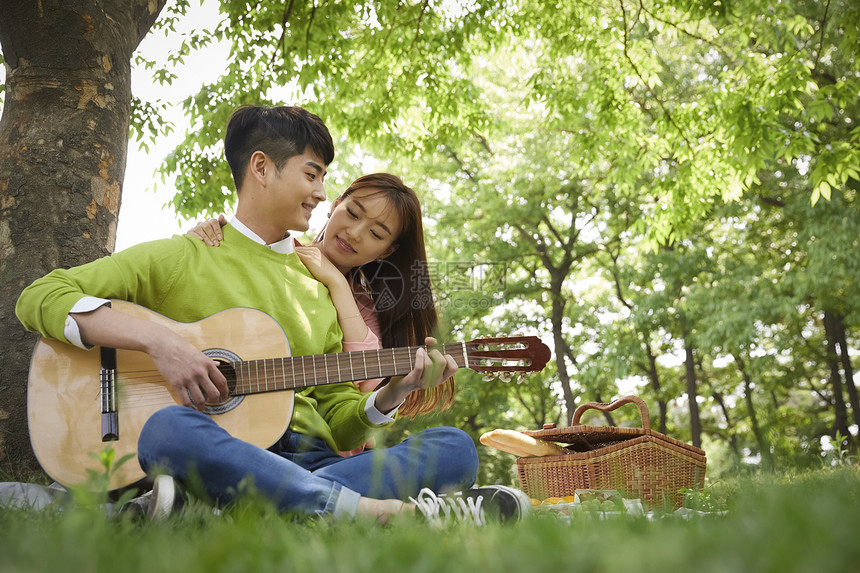 公园野餐弹吉他放松的情侣图片