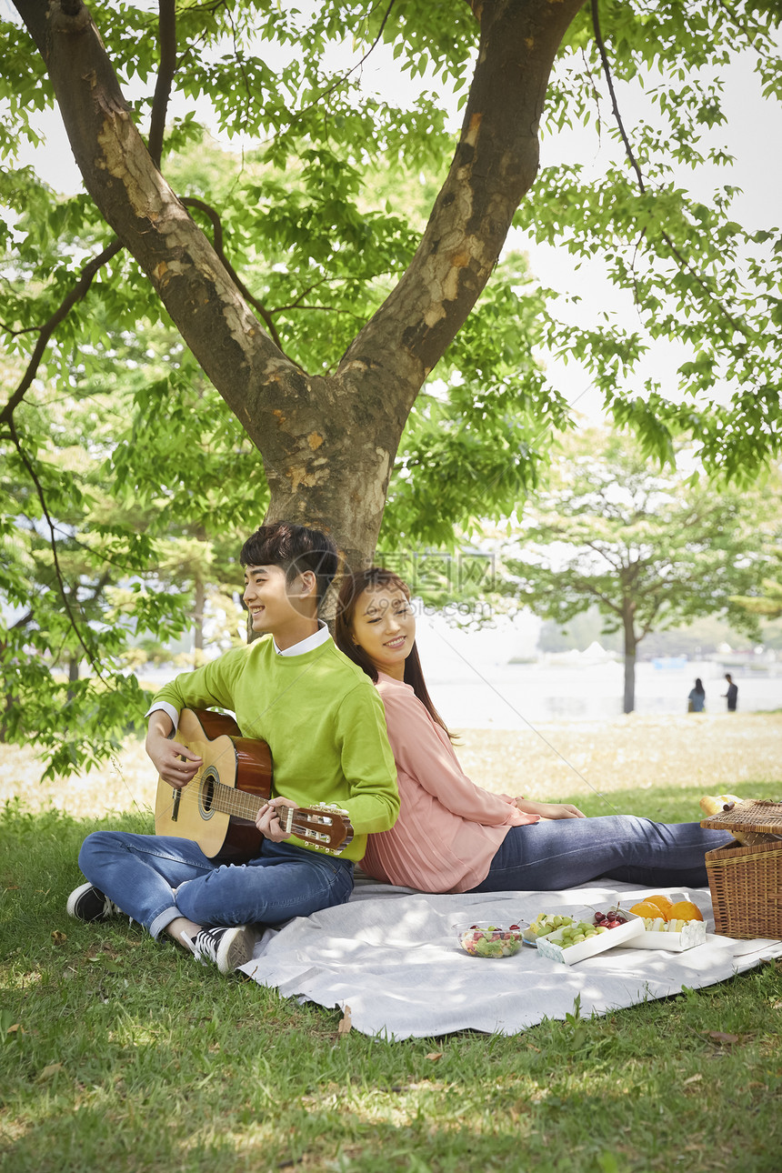 春日公园野餐放松的情侣图片