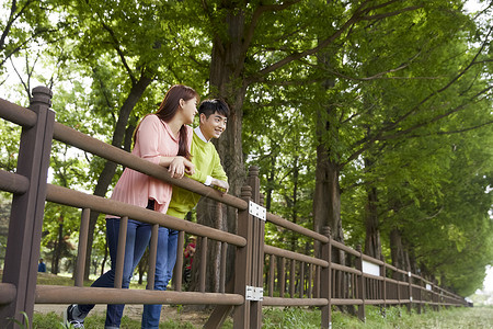 公园郊游靠在栏杆上看风景的情侣图片