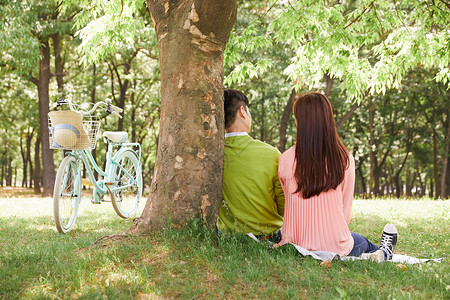 春日户外郊游野餐的情侣背影图片