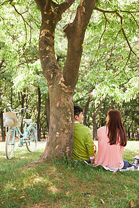 春日郊游野餐的情侣背影图片