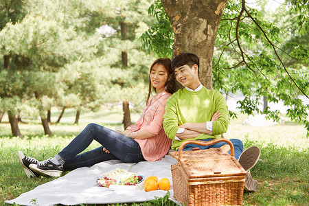 春日郊游野餐垫上休息的夫妇图片