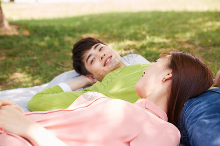 躺在野餐垫上休息的年轻情侣图片