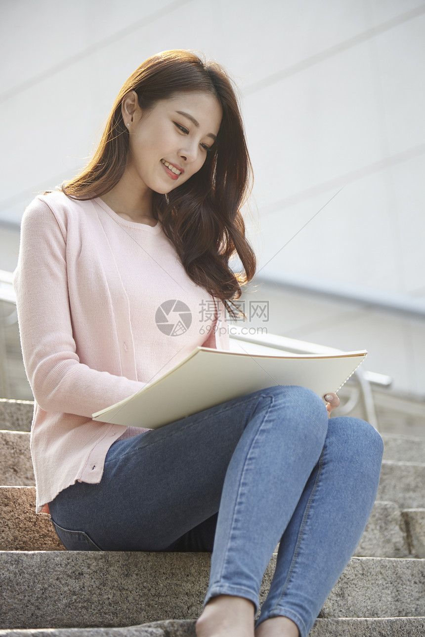 坐在台阶上写生的女大学生图片