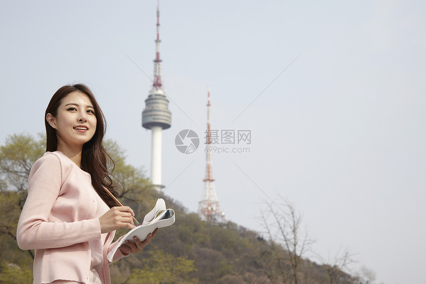 拿着笔记本记录的女大学生图片