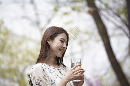 拿着水杯微笑的女青年图片