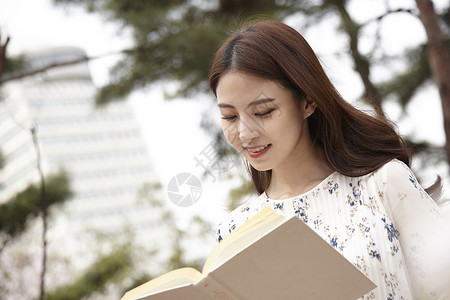 看书微笑的女大学生图片