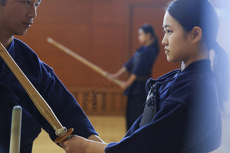 教练指导拿着木剑练习的少女图片