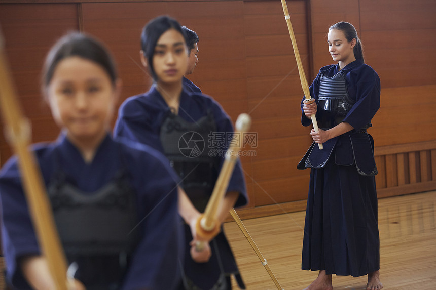 教练指导着拿着训练木剑的女孩图片