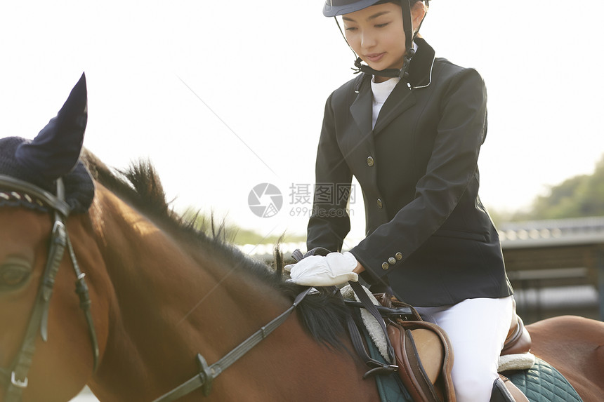 骑马场骑马的年轻女性图片