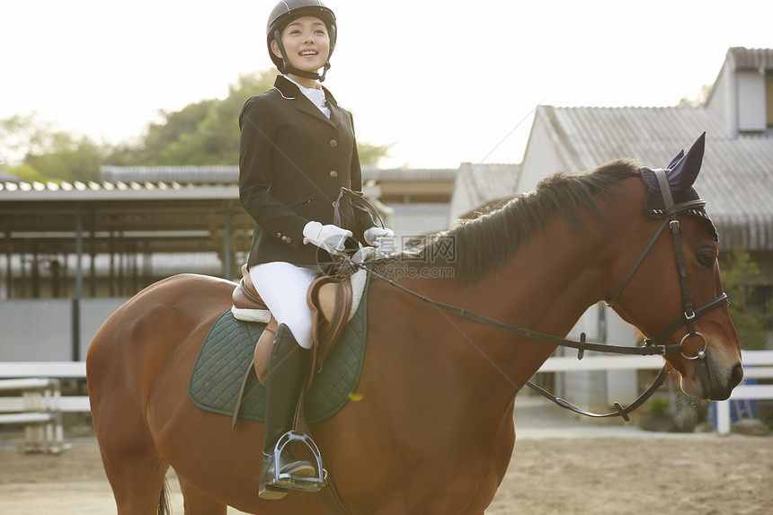 马术俱乐部骑马的年轻女性图片