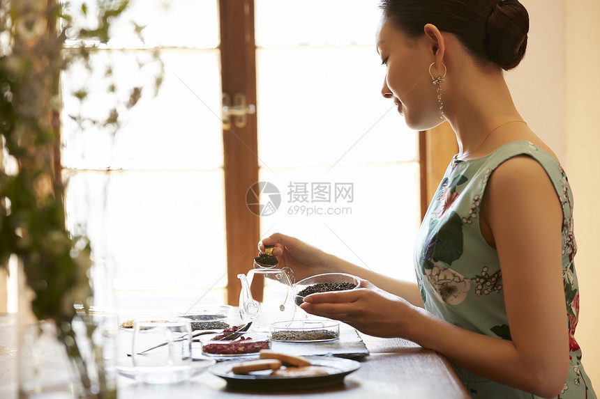 享受优雅下午茶泡茶的气质女性图片