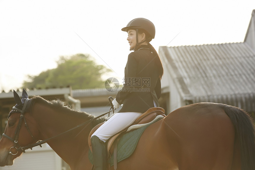日落骑马的年轻女性图片