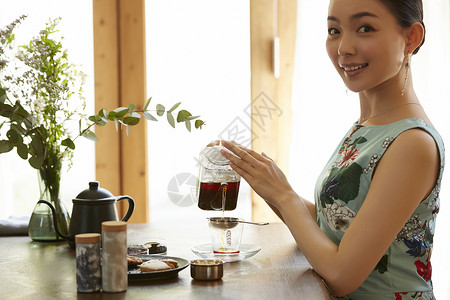 优雅的享受下午茶时间的年轻女性图片