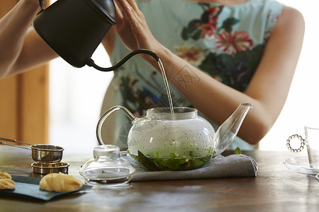 享受优雅的下午茶泡茶的女性特写图片