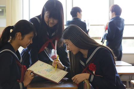 毕业留言册在毕业纪念簿上写留言的女孩们背景