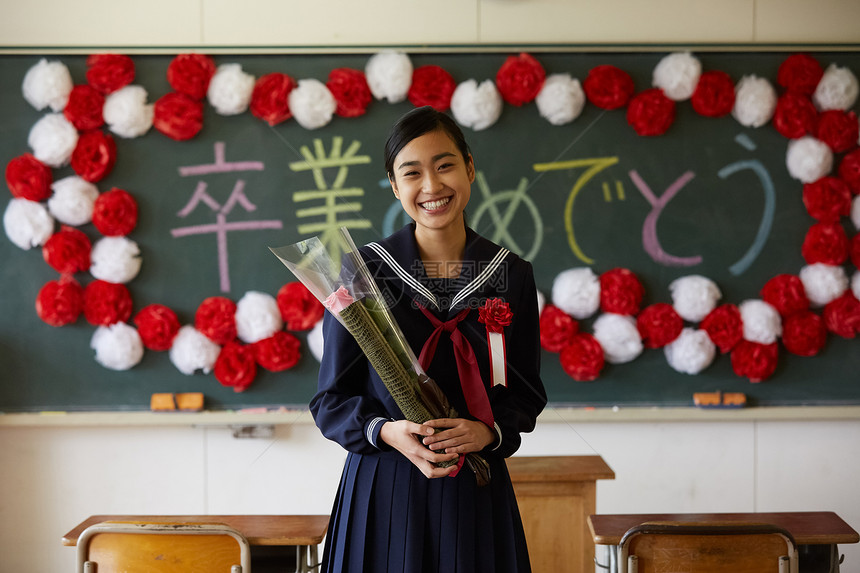 毕业典礼拿着花和证书微笑的女孩图片