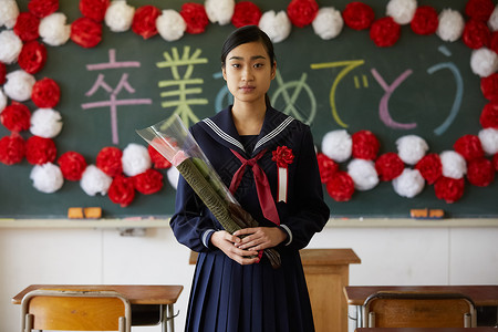 毕业典礼拿着花和证书的少女图片