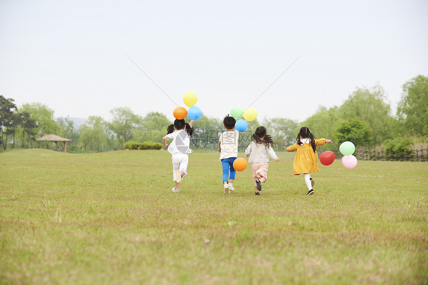 公园里拿着气球奔跑的孩子们图片