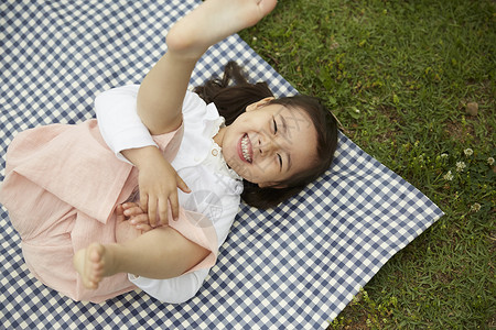 躺在野餐垫上兴奋的小女孩图片