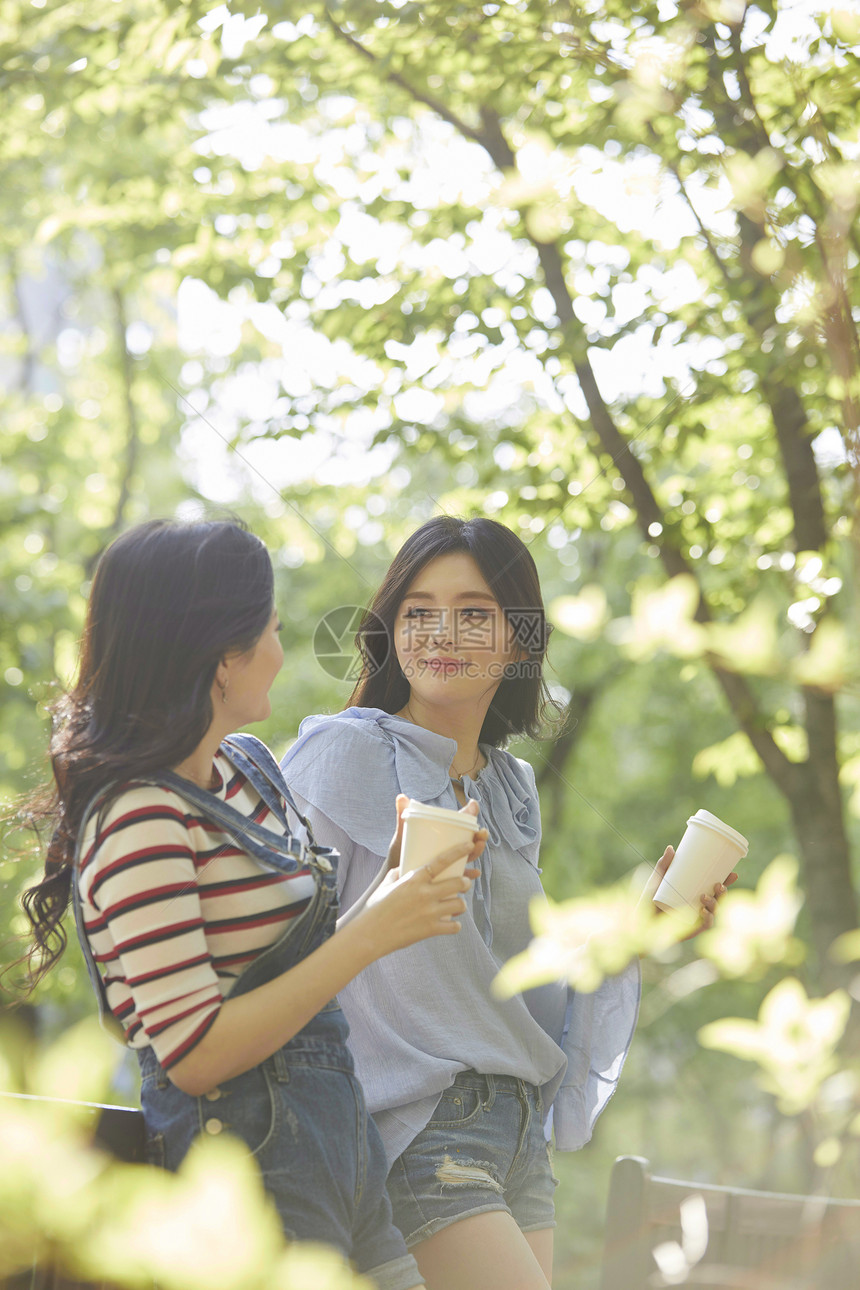 靠在栏杆上聊天的年轻女子图片