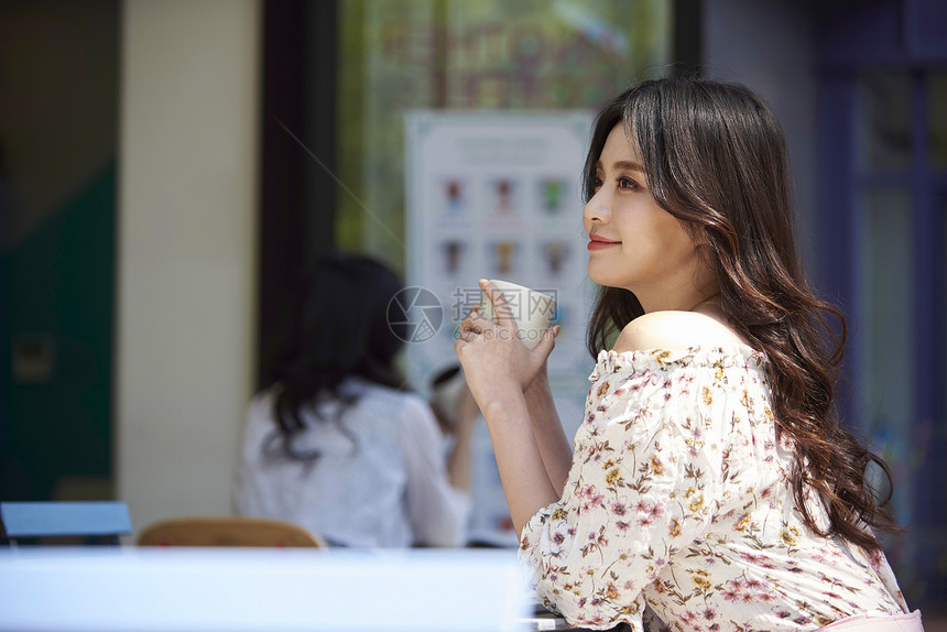 坐在咖啡馆享受生活的年轻女子图片