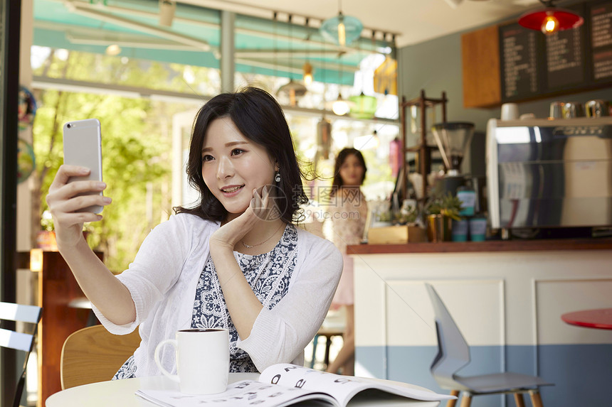 咖啡馆里自拍的年轻女人图片