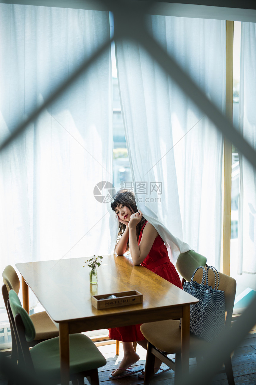 坐在窗边的年轻女性图片