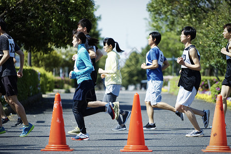 锥形交通路标参加户外马拉松比赛的奔跑者背景
