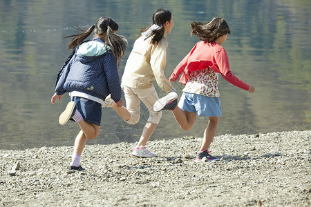 在湖边奔跑玩耍的小孩图片