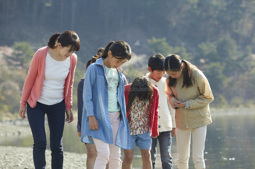 假期户外活动小学生在河边散步图片