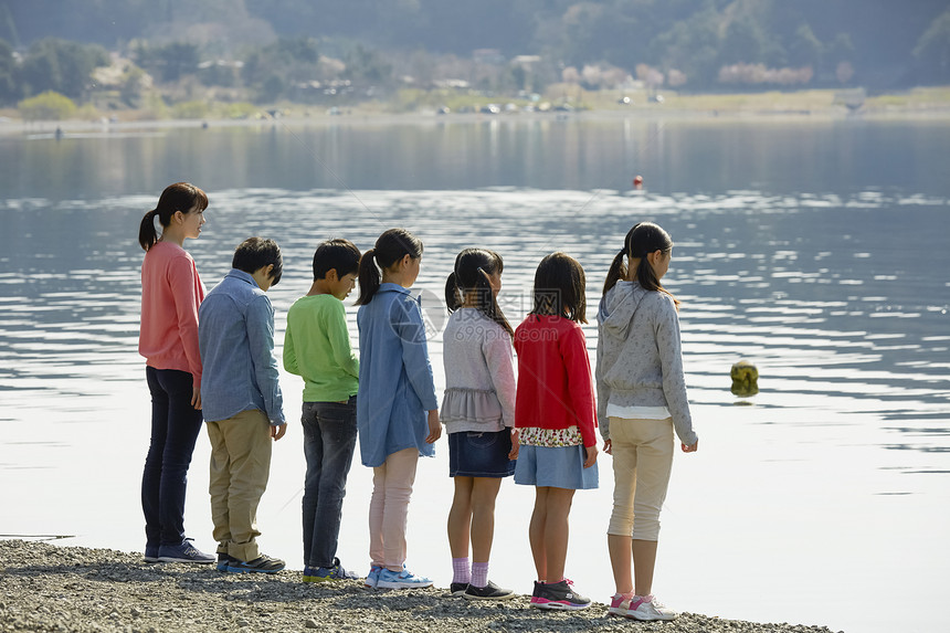 假期户外活动小学生在河边散步图片