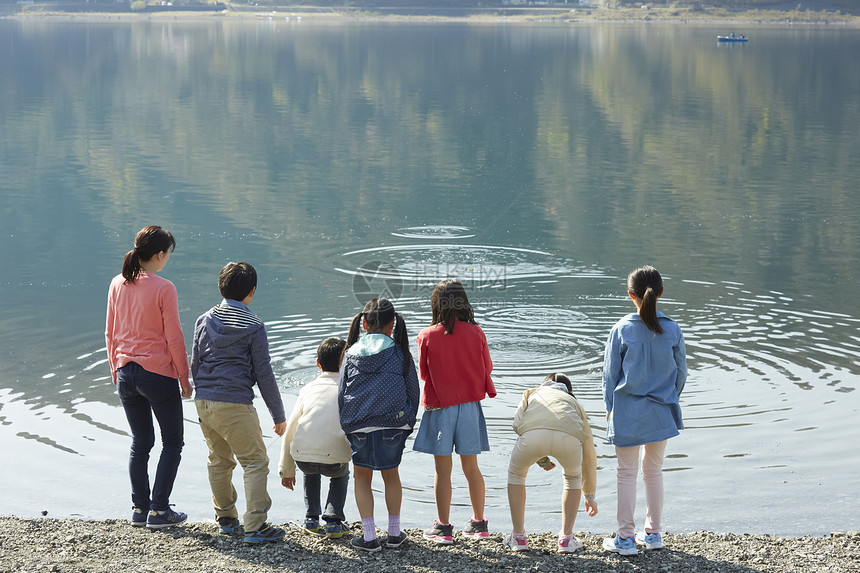 假期户外活动小学生在河边散步图片