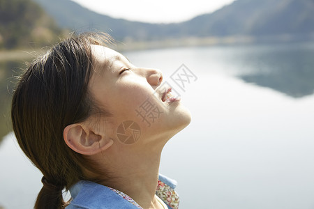 在湖边深呼吸放松的小女孩图片