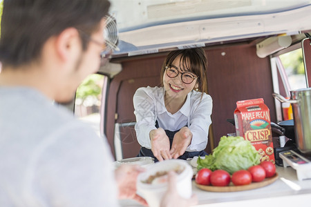 微笑着递出食物的年轻女性图片