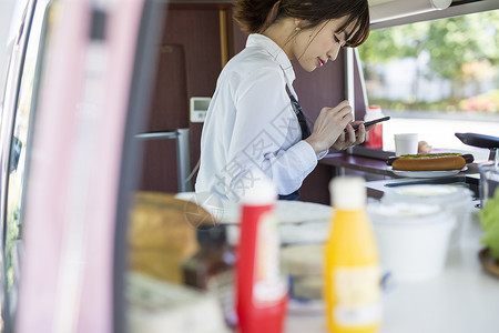 餐车里使用手机的年轻女性图片