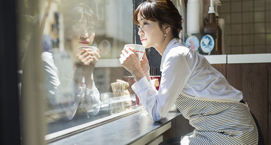 坐在窗台喝咖啡的女性图片