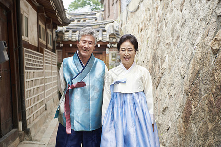 学说并排站着的穿朝鲜服饰的爷爷奶奶背景
