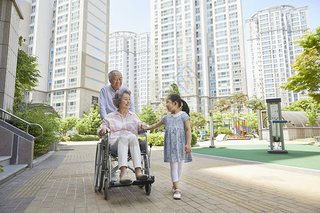 爷爷和小女孩推着轮椅上的奶奶图片