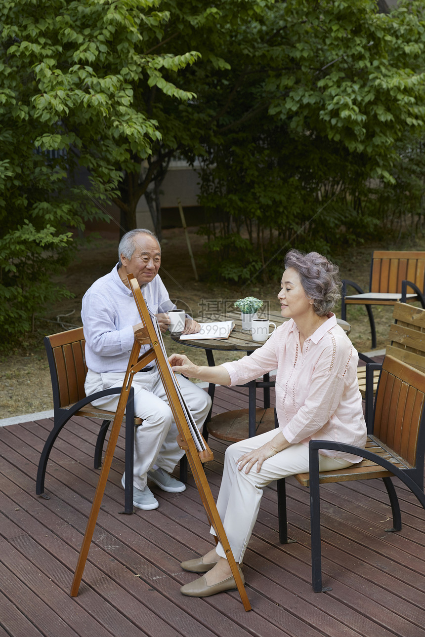 花园里绘画喝茶的退休老年夫妇图片