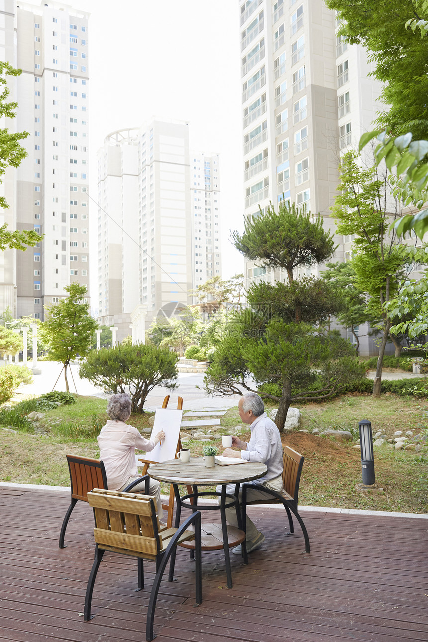 花园里绘画喝茶的退休老年夫妇图片