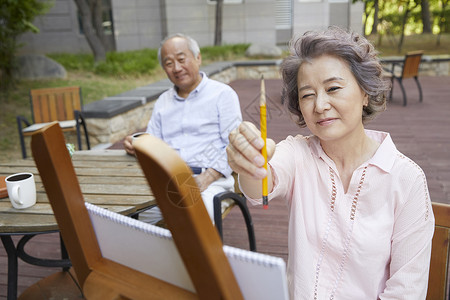 老年夫妇户外画画高清图片