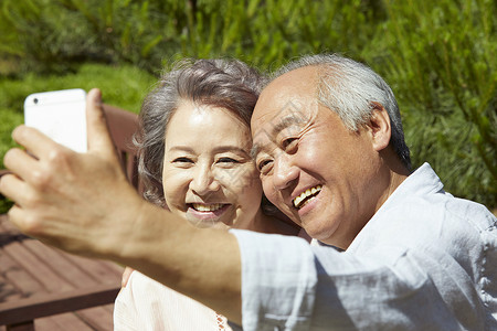 拿着手机开心自拍的老夫妇图片