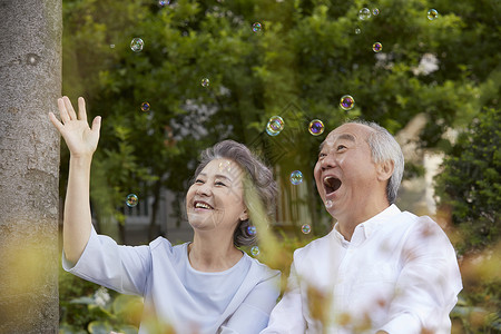 户外郊游看着泡泡开心的老年夫妇图片