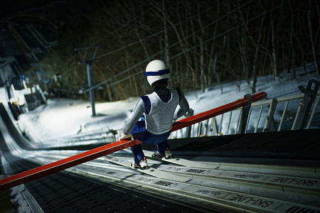 札幌滑雪场夜晚滑雪场大跳台训练的运动员背景