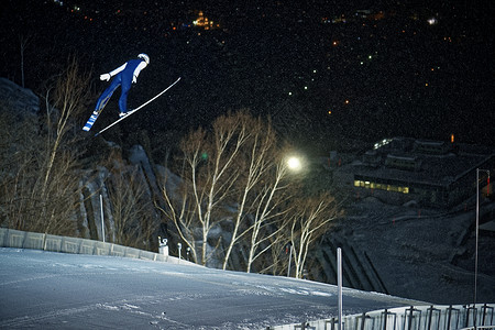 滑雪场跳跃滑翔的运动员图片